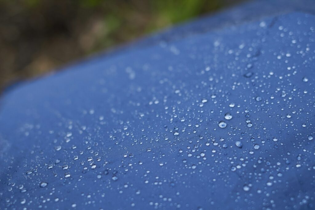 Water droplets beading on blue fabric